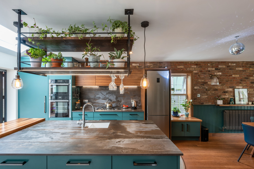 Mid-sized contemporary galley eat-in kitchen in Other with a drop-in sink, turquoise cabinets, quartzite benchtops, metallic splashback, slate splashback, stainless steel appliances, porcelain floors, white floor and multi-coloured benchtop.