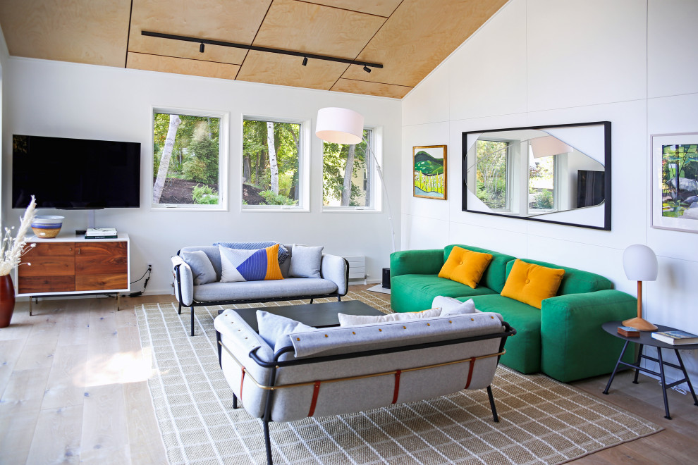 Imagen de salón abierto retro grande con paredes blancas, suelo de madera clara y madera