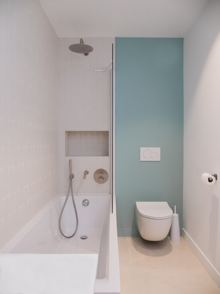 Foto på ett mellanstort funkis vit badrum för barn, med skåp i ljust trä, en dusch/badkar-kombination, vit kakel, blå väggar, cementgolv, ett nedsänkt handfat och grått golv