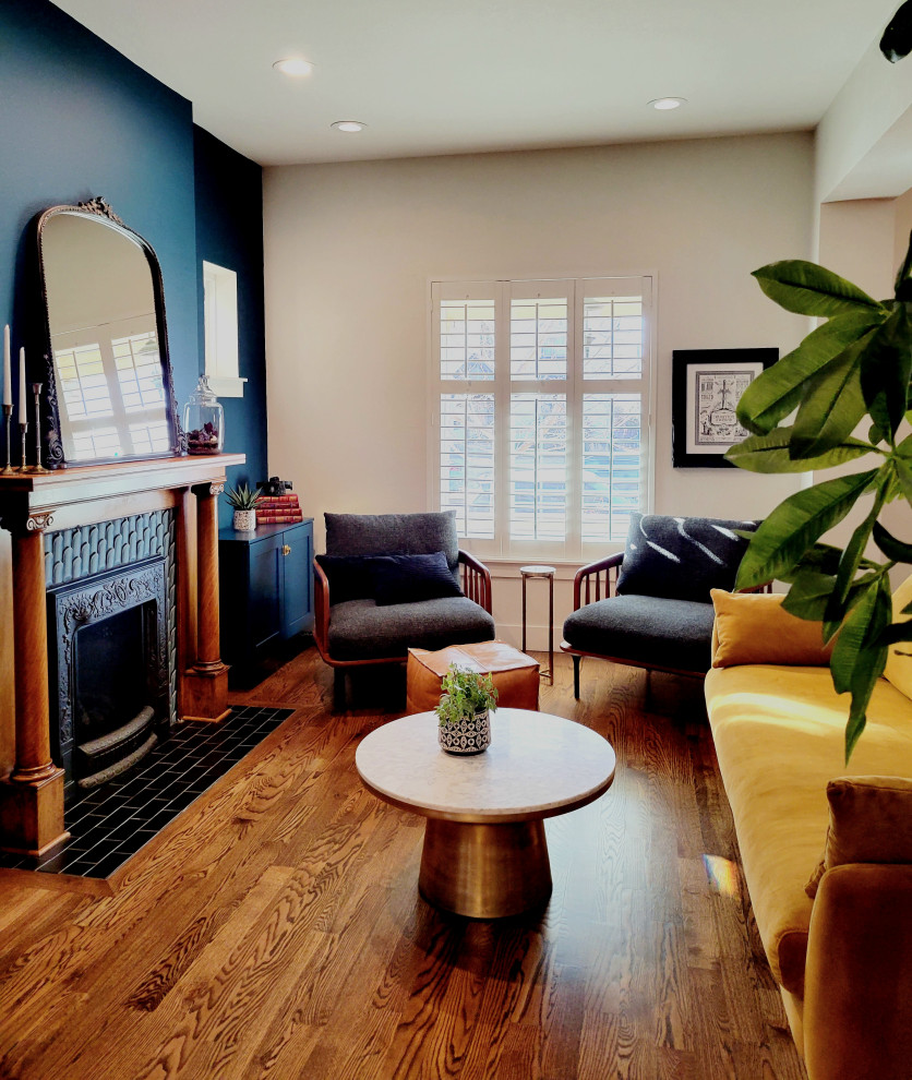Mittelgroßes Stilmix Wohnzimmer mit blauer Wandfarbe, braunem Holzboden, Kamin und gefliester Kaminumrandung in Denver