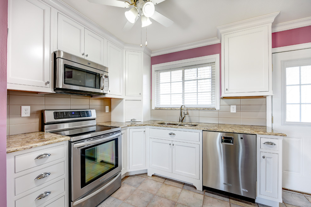 Example of a mid-sized classic u-shaped ceramic tile eat-in kitchen design with an undermount sink, recessed-panel cabinets, white cabinets, granite countertops, beige backsplash, ceramic backsplash, stainless steel appliances and no island