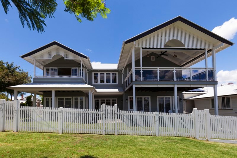 Photo of a mid-sized traditional two-storey grey exterior in Brisbane with wood siding and a gable roof.