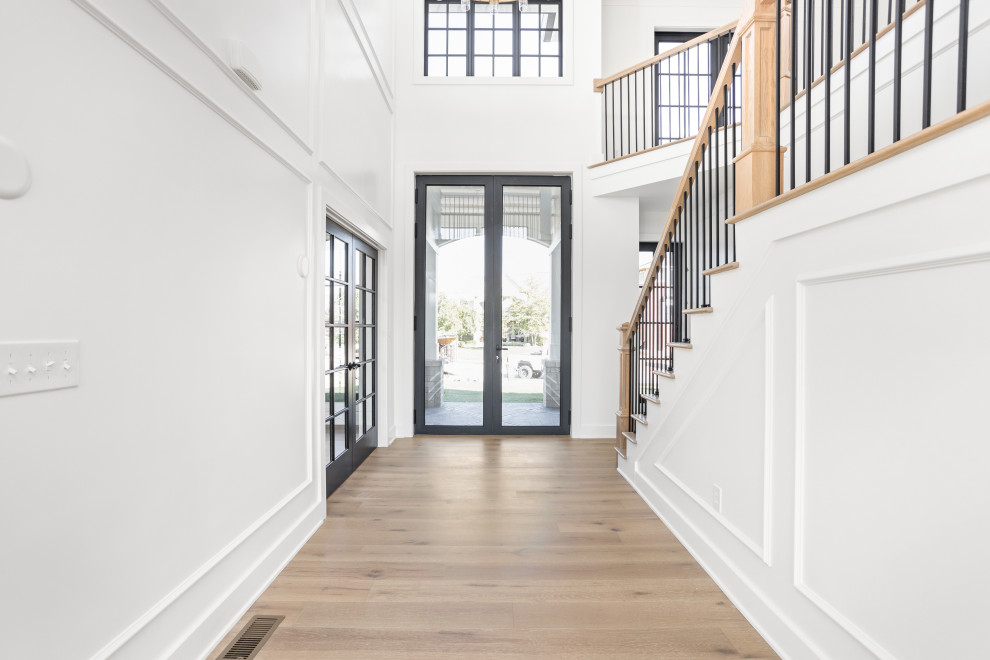 Large traditional front door in Indianapolis with white walls, light hardwood flooring, a double front door, a glass front door and multi-coloured floors.
