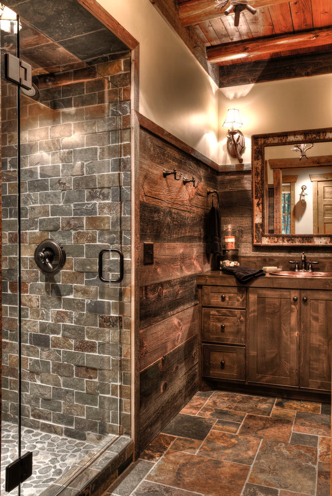 Country bathroom in Minneapolis with dark wood cabinets, wood benchtops, a drop-in sink, shaker cabinets, an alcove shower, brown tile, beige walls, brown floor, slate and brown benchtops.