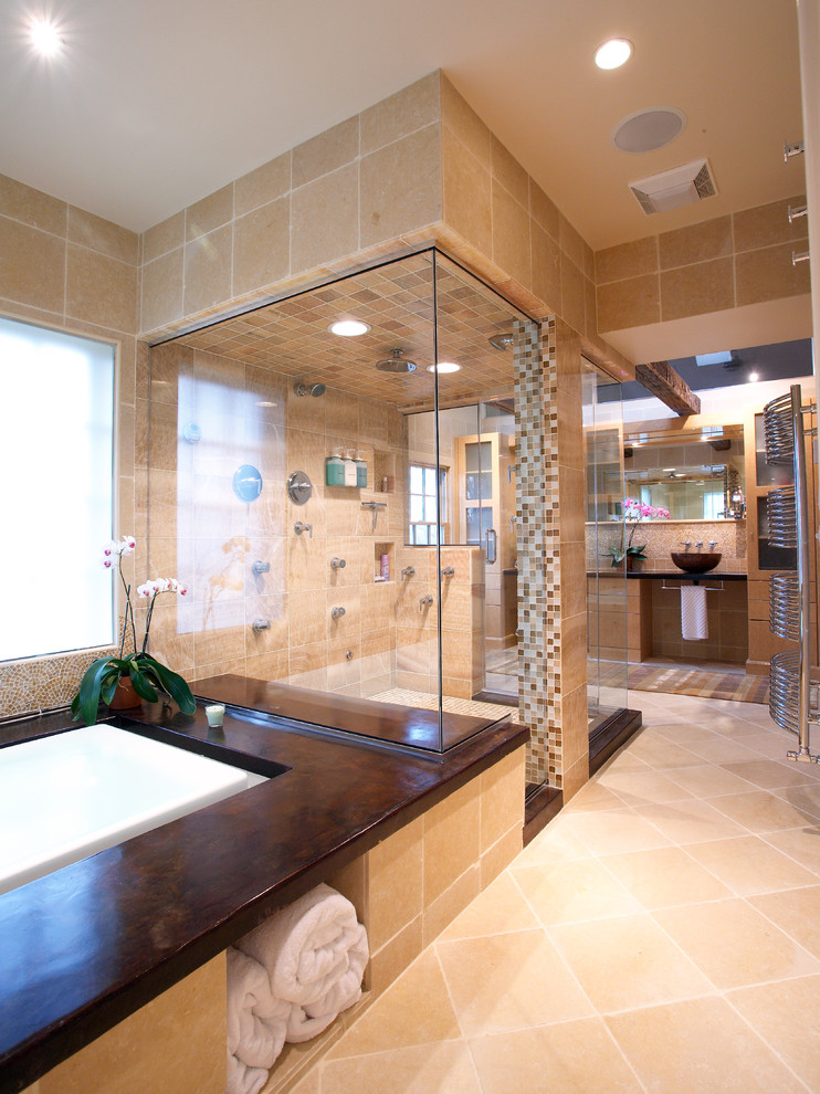 This is an example of an expansive contemporary master bathroom in Other with a drop-in tub, a corner shower, beige tile, limestone, beige walls, limestone floors, a vessel sink, beige floor and a hinged shower door.