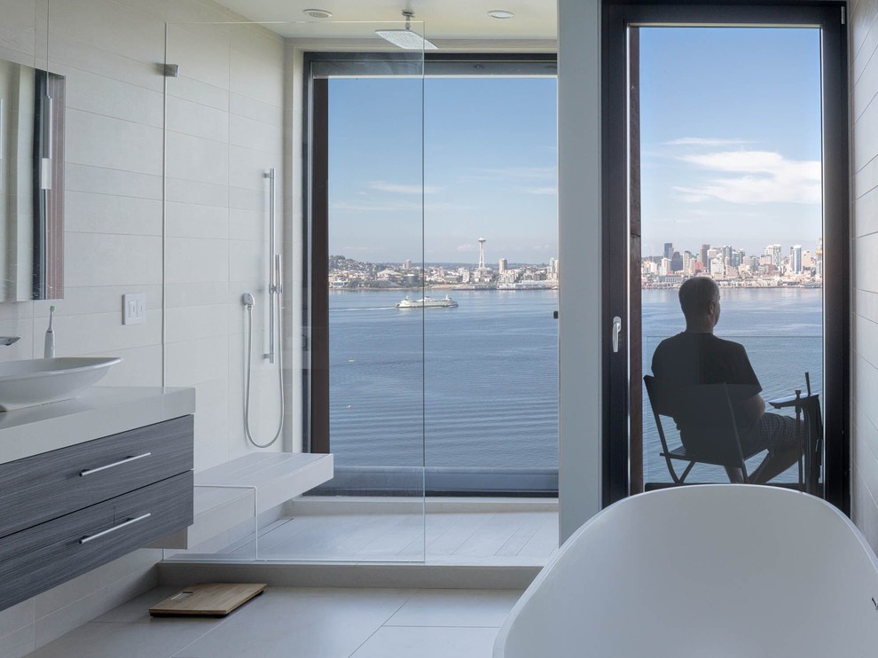 Photo of a modern master bathroom in Seattle with flat-panel cabinets, grey cabinets, a freestanding tub, white tile, a vessel sink, an open shower and an open shower.