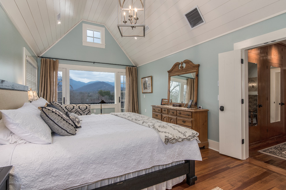 This is an example of a large transitional master bedroom in Other with blue walls and medium hardwood floors.