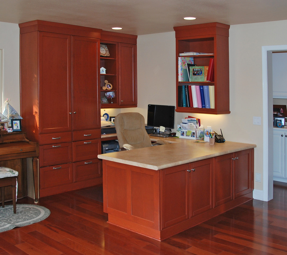 Design ideas for a mid-sized contemporary study room in San Luis Obispo with beige walls, dark hardwood floors, a built-in desk and red floor.