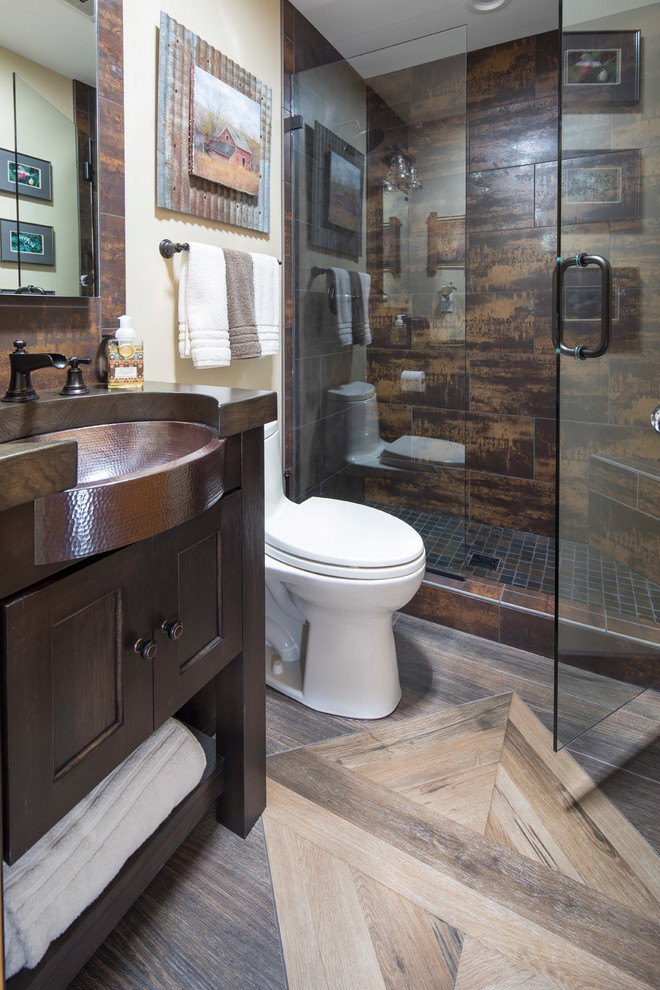 This is an example of a small contemporary kids bathroom in Minneapolis with recessed-panel cabinets, dark wood cabinets, an alcove shower, a one-piece toilet, brown tile, slate, beige walls, porcelain floors, an undermount sink, copper benchtops, multi-coloured floor and a hinged shower door.