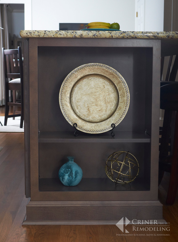 Eat-in kitchen - transitional light wood floor eat-in kitchen idea with shaker cabinets, dark wood cabinets, granite countertops, beige backsplash, glass tile backsplash, stainless steel appliances and an island