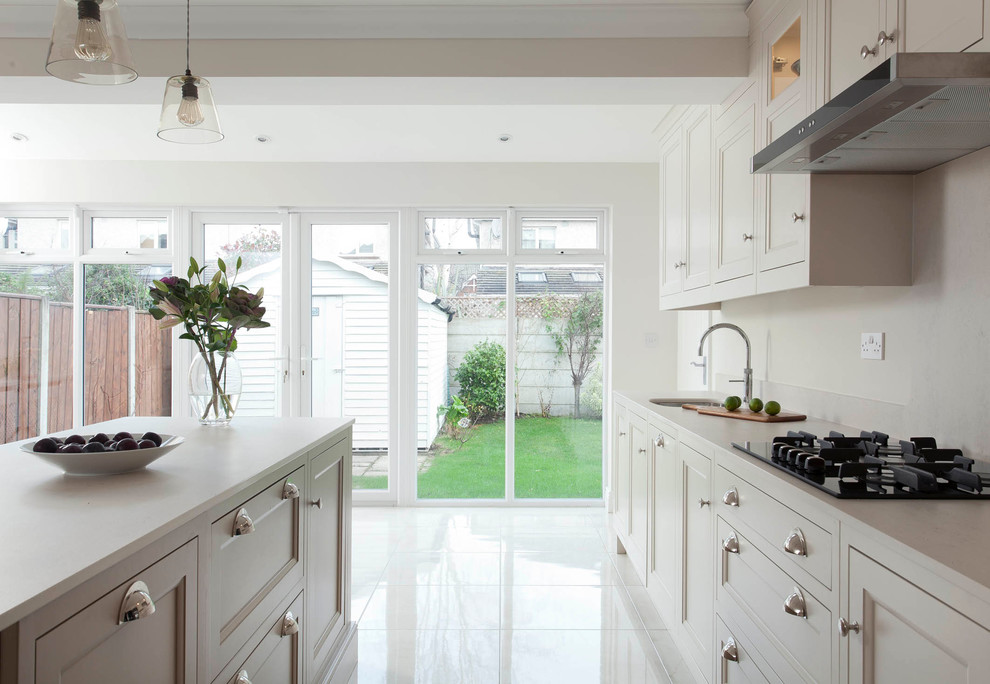 Design ideas for a large classic single-wall open plan kitchen in Dublin with a submerged sink, beaded cabinets, beige cabinets, quartz worktops, beige splashback, stone slab splashback, stainless steel appliances, porcelain flooring and an island.