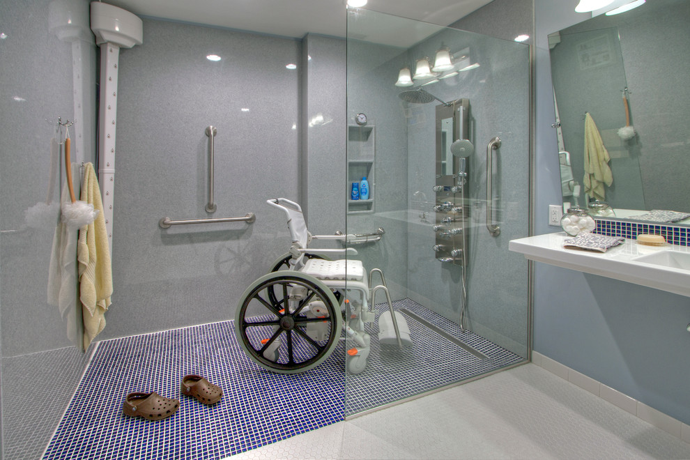 This is an example of a large contemporary master bathroom in St Louis with a curbless shower, a two-piece toilet, blue tile, ceramic tile, blue walls, linoleum floors and a wall-mount sink.