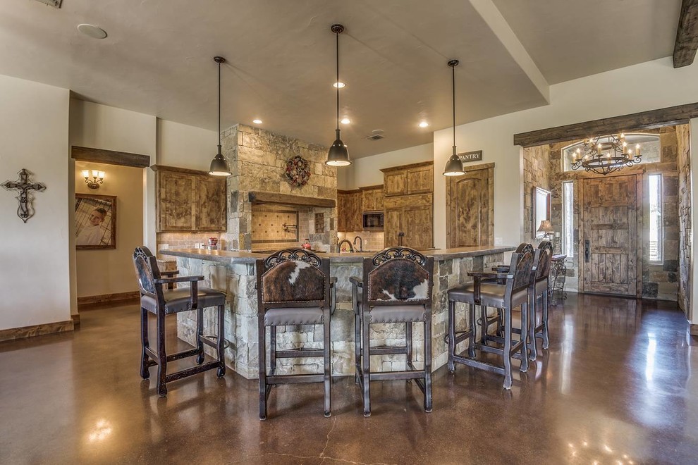 This is an example of a mid-sized country l-shaped open plan kitchen in Austin with a farmhouse sink, shaker cabinets, dark wood cabinets, granite benchtops, grey splashback, ceramic splashback, stainless steel appliances, concrete floors, multiple islands, brown floor and brown benchtop.
