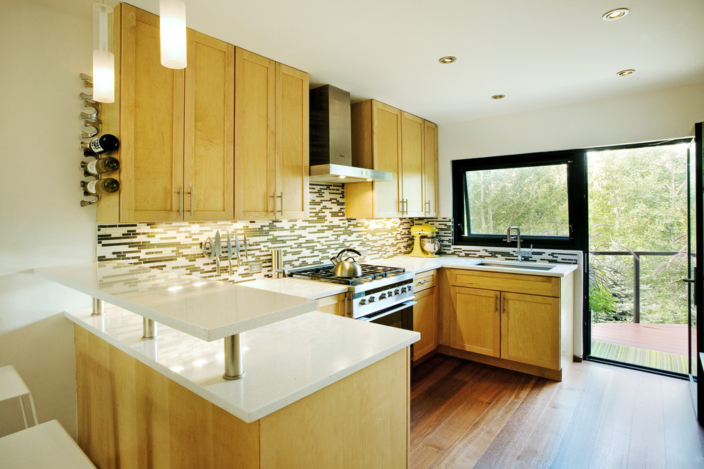 Photo of a transitional open plan kitchen in Denver with shaker cabinets, light wood cabinets, matchstick tile splashback and multi-coloured splashback.
