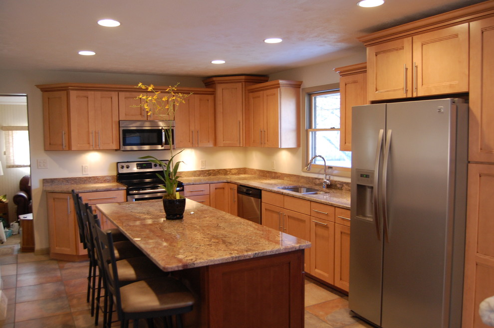 Inspiration for a transitional l-shaped ceramic tile eat-in kitchen remodel in Cleveland with a drop-in sink, raised-panel cabinets, light wood cabinets, marble countertops, white backsplash, stainless steel appliances and an island