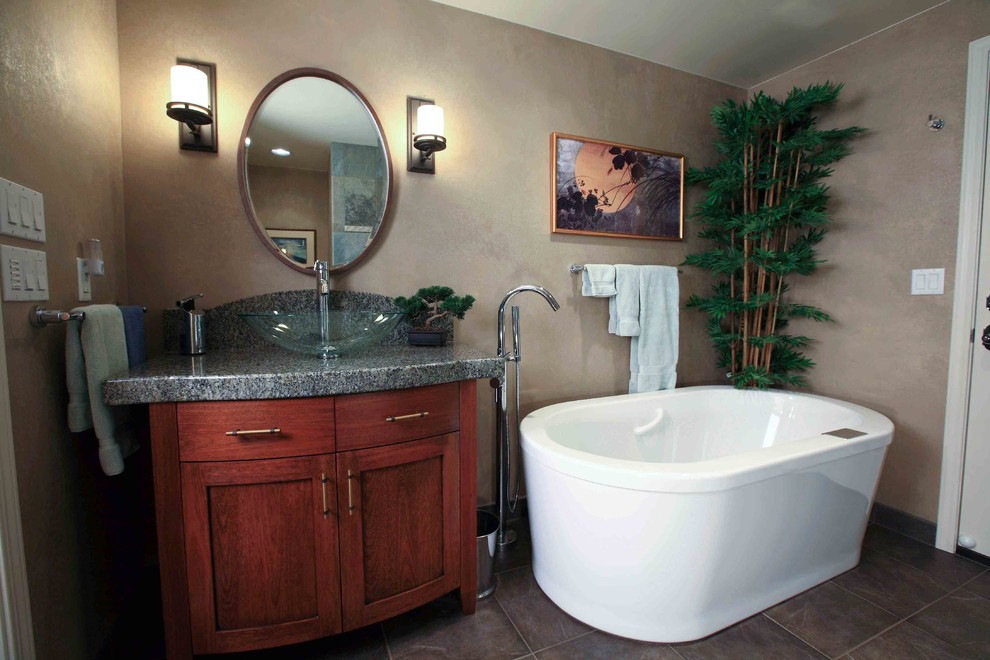 Inspiration for a mid-sized transitional master brown tile and ceramic tile porcelain tile freestanding bathtub remodel in Seattle with a vessel sink, recessed-panel cabinets, medium tone wood cabinets, granite countertops, a two-piece toilet and gray walls