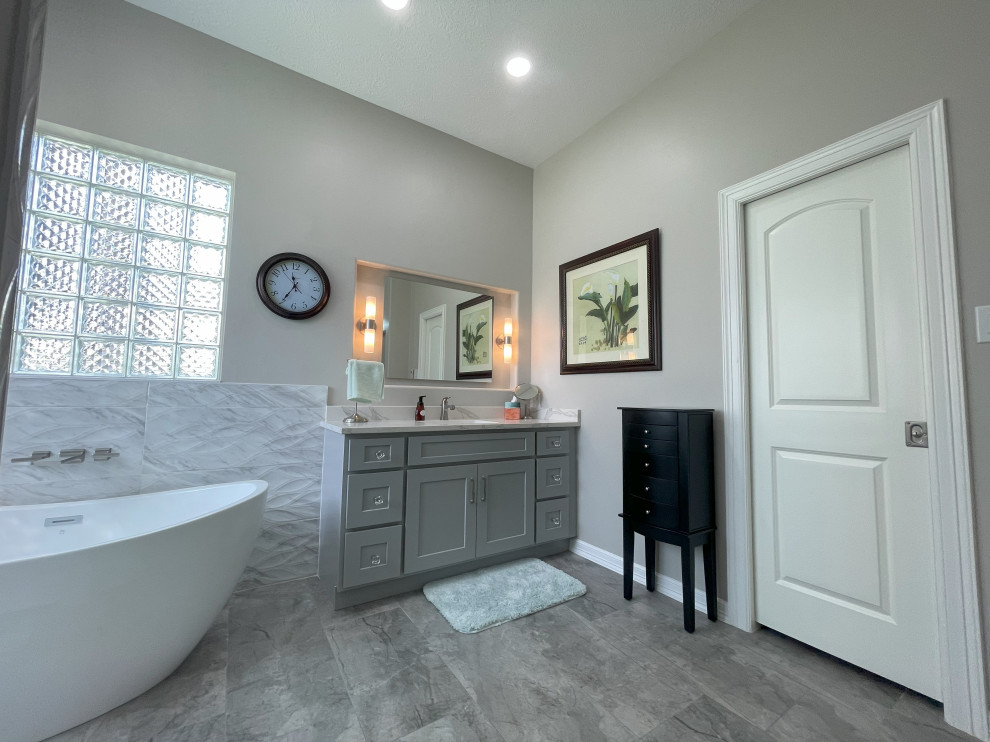 This is an example of a contemporary bathroom in Houston with shaker cabinets, grey cabinets, a freestanding tub, an open shower, porcelain tile, porcelain floors, an undermount sink, engineered quartz benchtops, white benchtops, a double vanity and a built-in vanity.