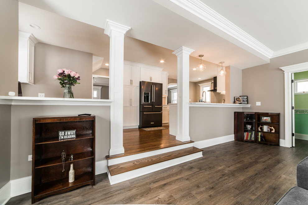 Mid-sized transitional l-shaped medium tone wood floor and brown floor eat-in kitchen photo in Chicago with an undermount sink, recessed-panel cabinets, white cabinets, quartzite countertops, gray backsplash, subway tile backsplash, black appliances, no island and multicolored countertops