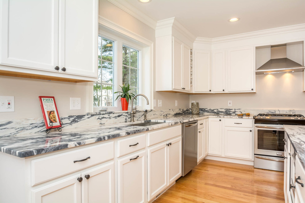 Eat-in kitchen - large transitional l-shaped brown floor and medium tone wood floor eat-in kitchen idea in Boston with an undermount sink, recessed-panel cabinets, white cabinets, stone slab backsplash, stainless steel appliances, an island and quartzite countertops