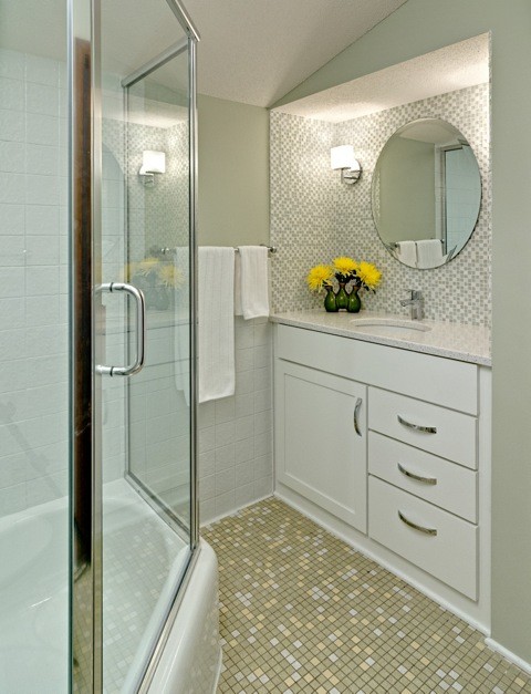 Photo of a mid-sized midcentury bathroom in Minneapolis with an undermount sink, recessed-panel cabinets, white cabinets, engineered quartz benchtops, an alcove tub, a shower/bathtub combo, a two-piece toilet, multi-coloured tile, ceramic tile, green walls and mosaic tile floors.