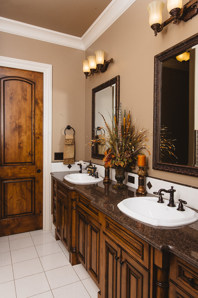 This is an example of a large arts and crafts master bathroom in Other with recessed-panel cabinets, dark wood cabinets, a two-piece toilet, black and white tile, porcelain tile, brown walls, porcelain floors, a drop-in sink, granite benchtops and a claw-foot tub.
