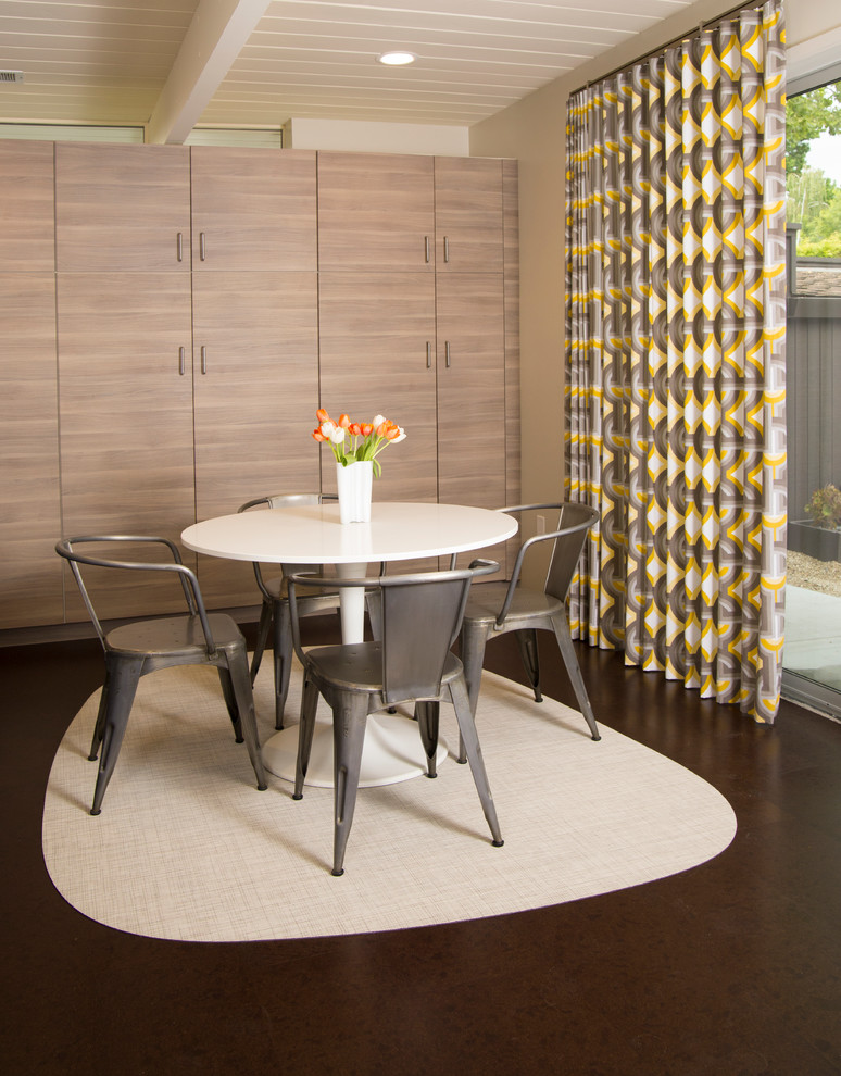 This is an example of a small midcentury dining room in San Francisco with beige walls and cork floors.