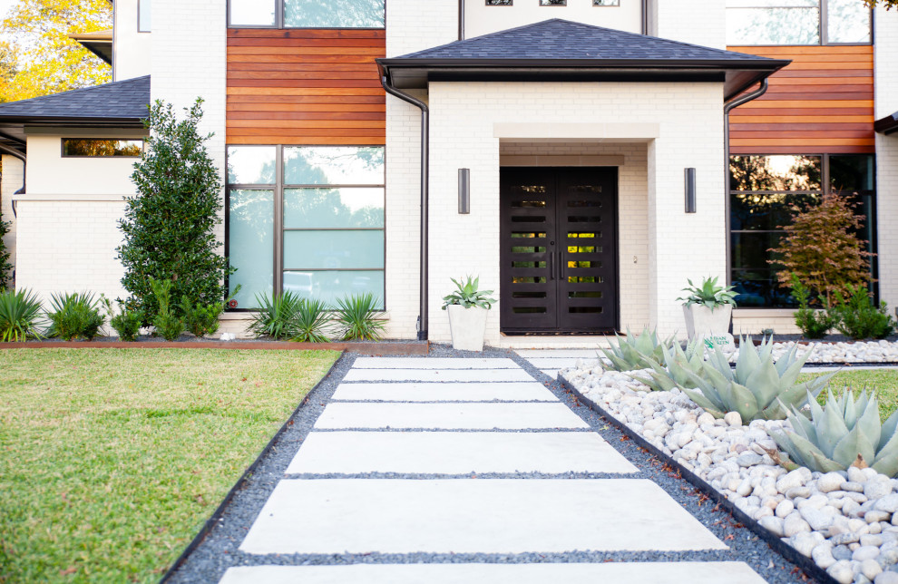 Design ideas for a mid-sized modern front yard full sun xeriscape in Dallas with with rock feature, river rock and a wood fence.