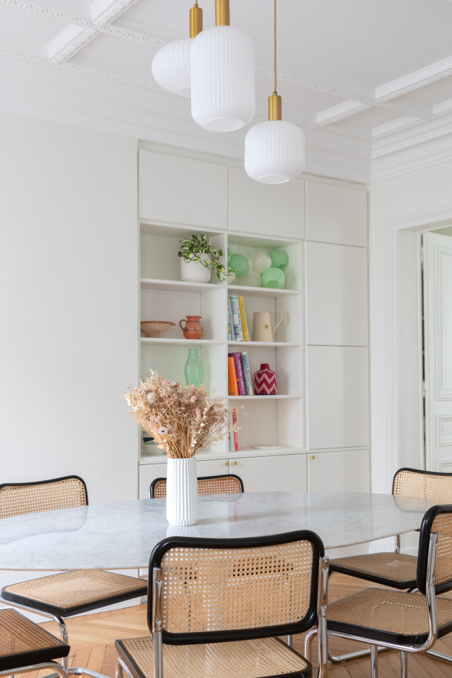 Immagine di una grande sala da pranzo aperta verso la cucina scandinava con pareti bianche e parquet chiaro