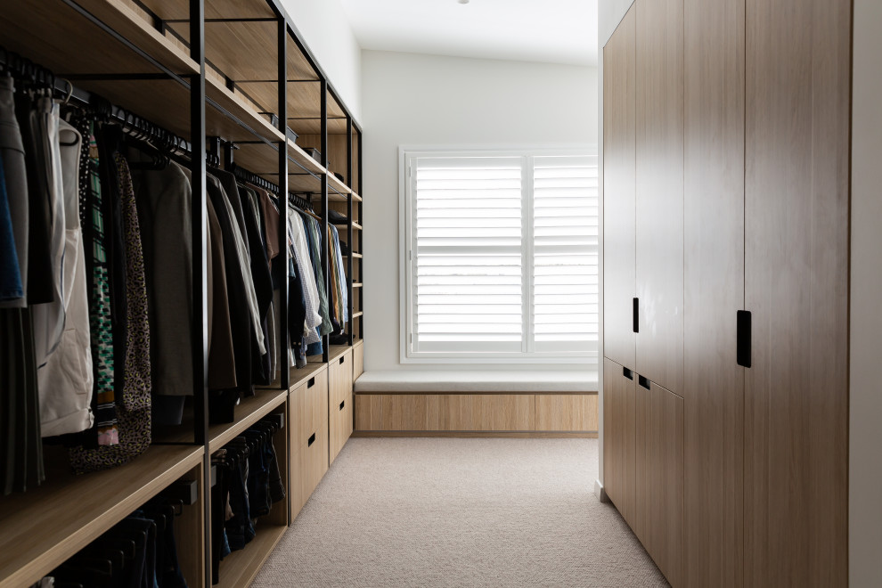 Inspiration for a large mid-century modern gender-neutral carpeted and beige floor walk-in closet remodel in Sydney with flat-panel cabinets and light wood cabinets