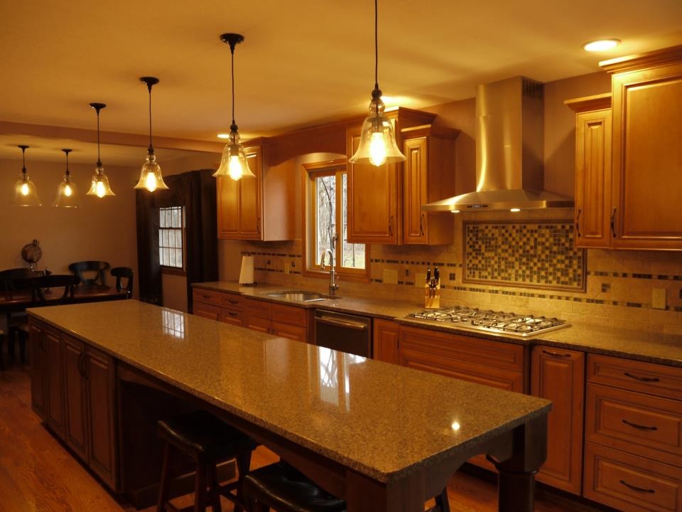 Eat-in kitchen - large transitional galley light wood floor eat-in kitchen idea in Grand Rapids with an undermount sink, raised-panel cabinets, light wood cabinets, quartzite countertops, beige backsplash, ceramic backsplash, stainless steel appliances and an island