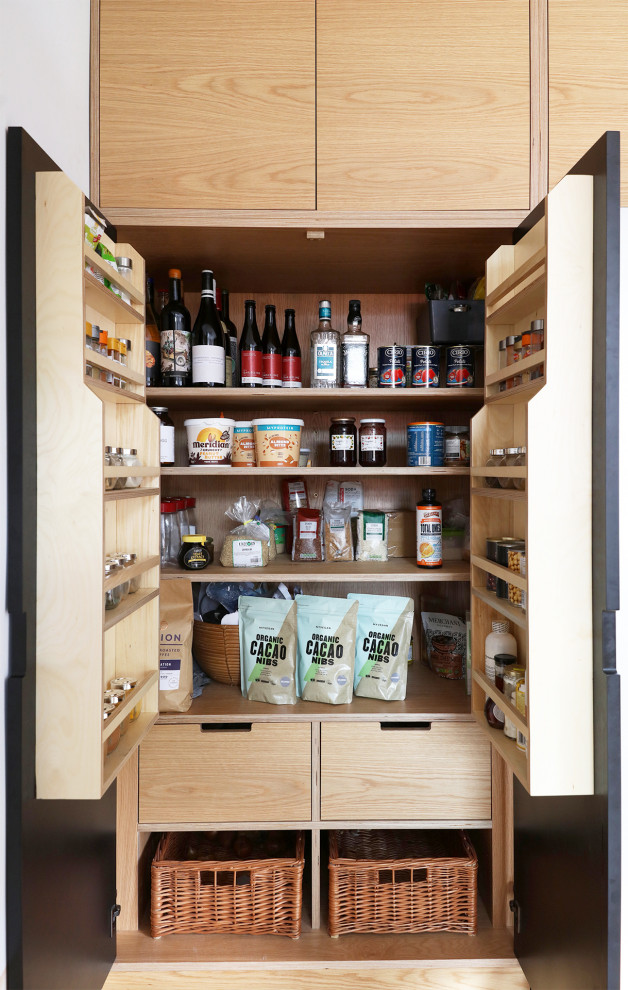 Diseño de cocinas en U escandinavo de tamaño medio con armarios con paneles lisos, puertas de armario de madera clara, encimera de cuarzo compacto y encimeras negras