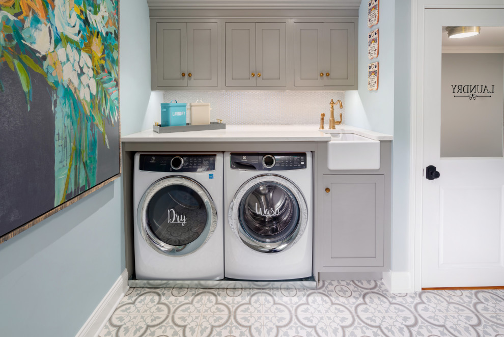 フィラデルフィアにある広いおしゃれな洗濯室 (グレーのキャビネット、青い壁、左右配置の洗濯機・乾燥機、マルチカラーの床、白いキッチンカウンター) の写真