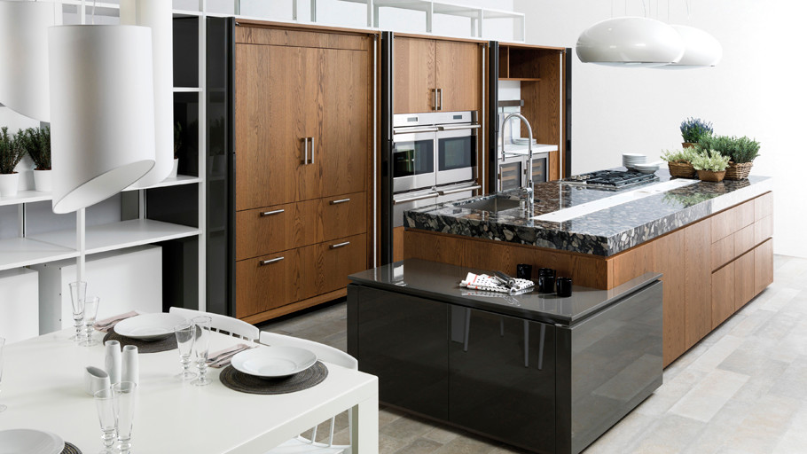 Réalisation de cuisine ouverte en bois brun avec un évier intégré, un placard à porte plane, un plan de travail en granite, tomettes au sol et îlot.