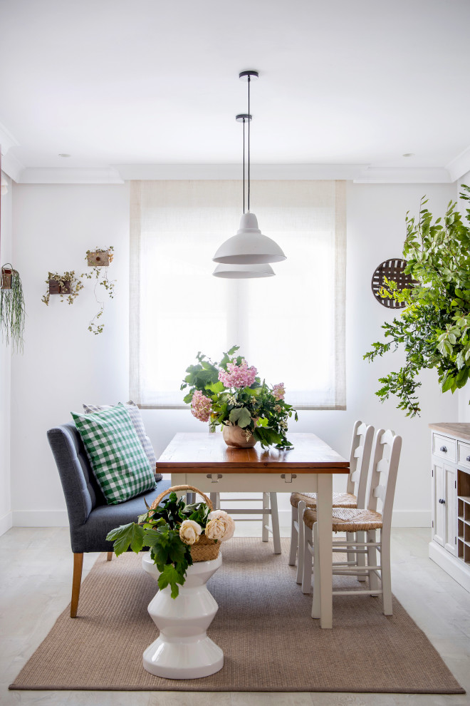 Idée de décoration pour une salle à manger champêtre avec un mur blanc et un sol gris.