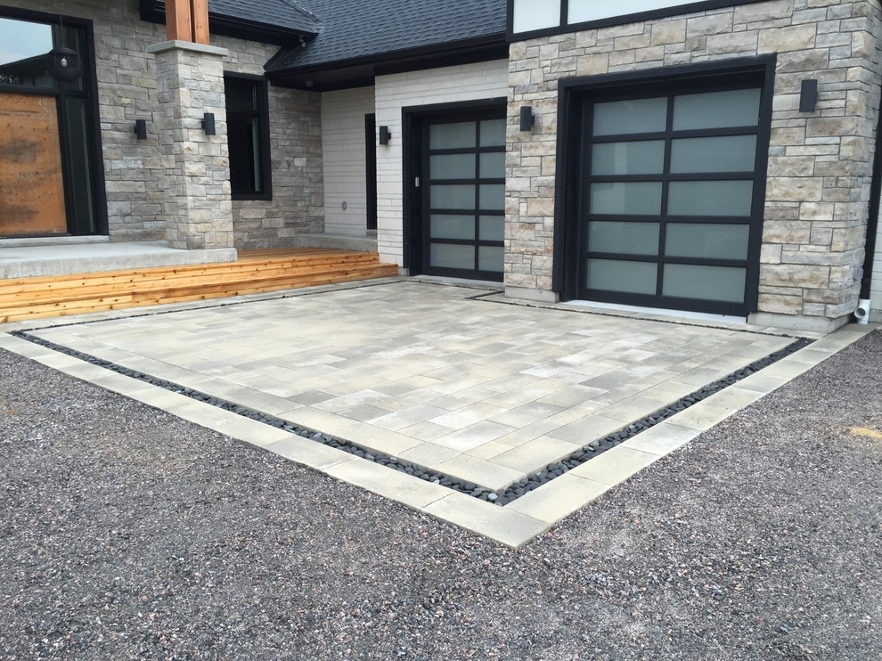 This is an example of a mid-sized contemporary attached two-car garage in Toronto.