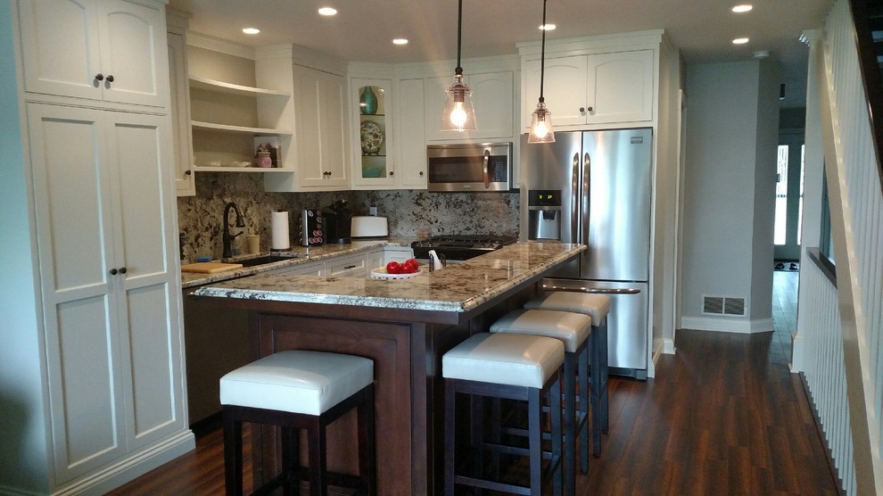 Kitchen - transitional l-shaped dark wood floor kitchen idea with a farmhouse sink, raised-panel cabinets, white cabinets, granite countertops, marble backsplash, black appliances and an island