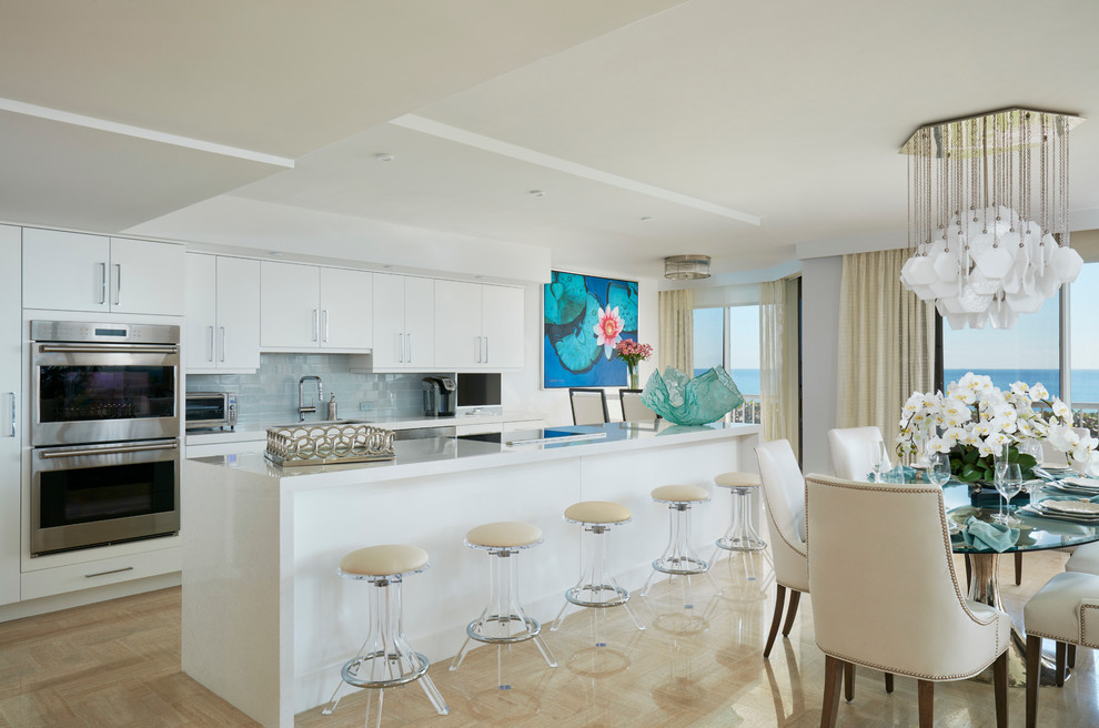 Inspiration for a transitional kitchen in Miami with an undermount sink, flat-panel cabinets, white cabinets, quartz benchtops, blue splashback, glass tile splashback, stainless steel appliances, travertine floors and with island.