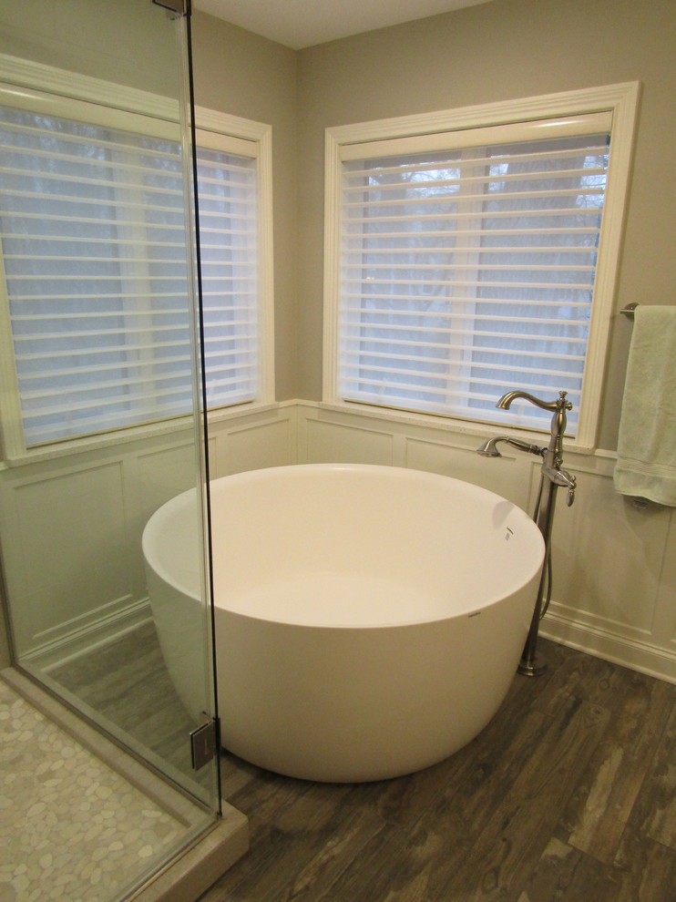 Inspiration for a mid-sized transitional master white tile and stone tile porcelain tile and brown floor freestanding bathtub remodel with shaker cabinets, dark wood cabinets, gray walls, an undermount sink, granite countertops and a hinged shower door