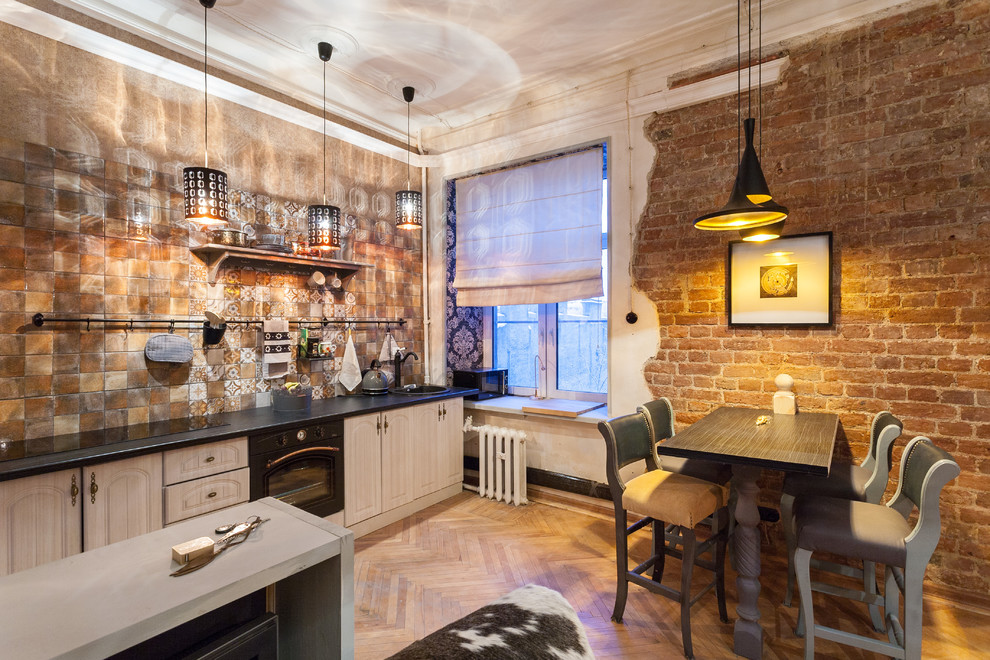 This is an example of a small industrial eat-in kitchen in Moscow with medium hardwood floors.