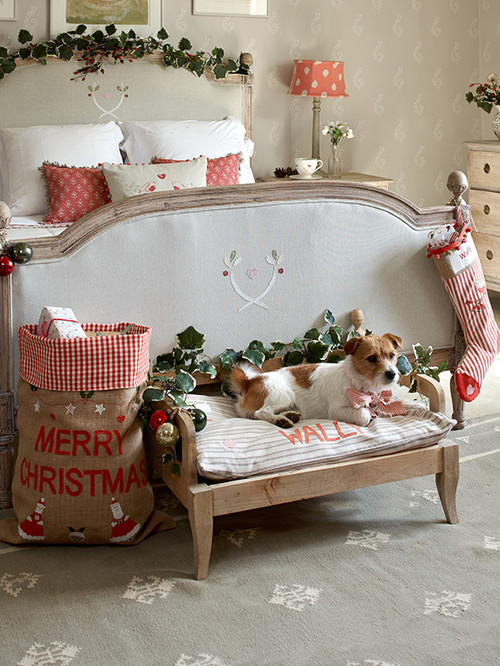 Holiday Decor Ideas for Dog Lovers - Bedroom with white beding and a dog on a raised dog bed at the foot of the bed. 