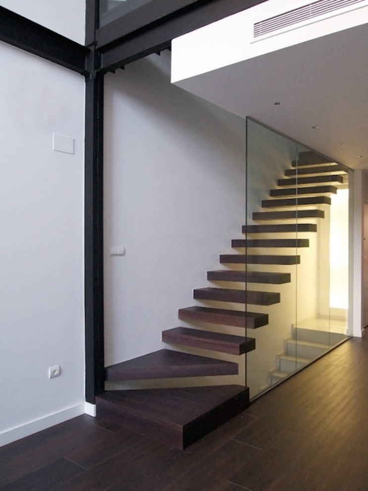 Photo of a mid-sized contemporary wood straight staircase in Valencia with open risers.