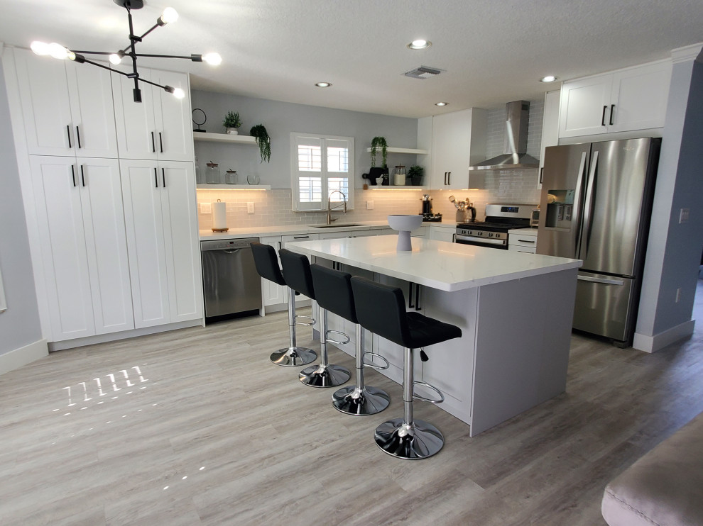 Kitchen pantry - large transitional l-shaped kitchen pantry idea in Miami with shaker cabinets, white cabinets, quartz countertops and an island