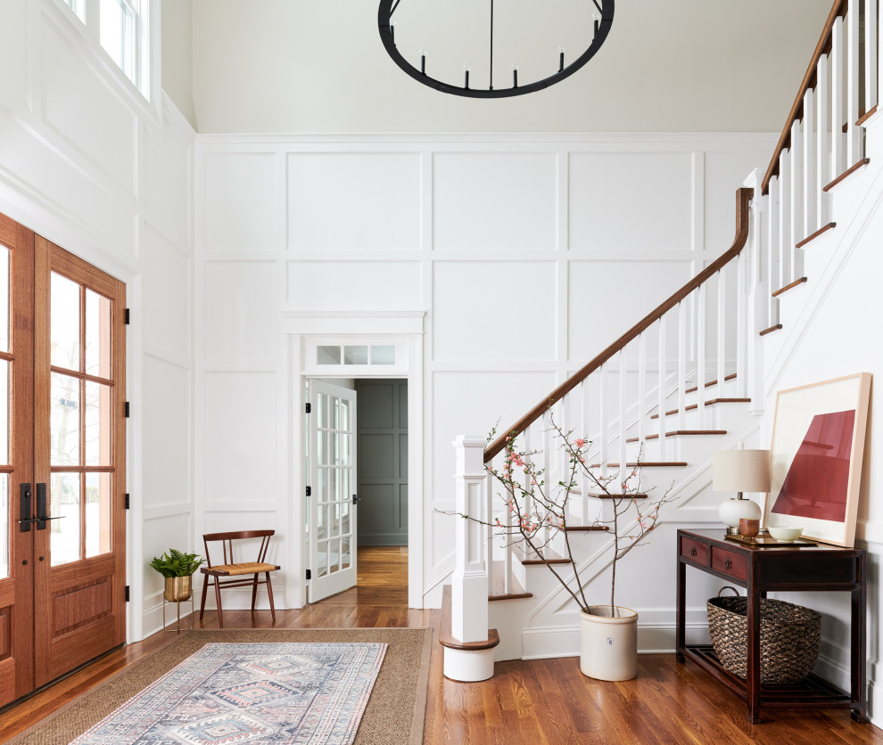 Inspiration for a transitional foyer in New York with white walls, medium hardwood floors, a double front door, a medium wood front door and brown floor.