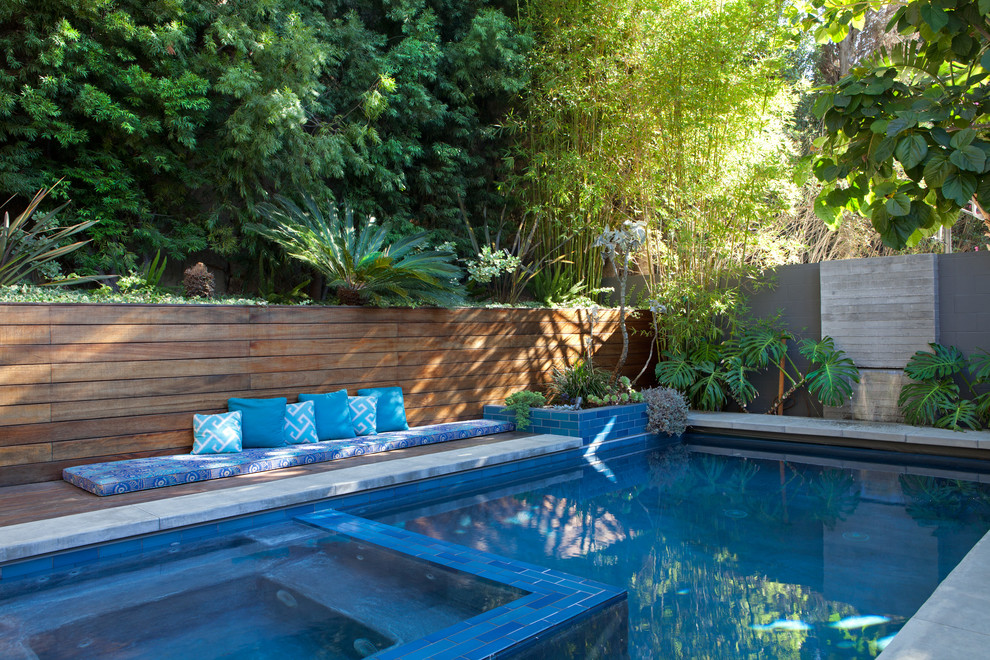 Photo of a large midcentury backyard rectangular lap pool in Los Angeles with a hot tub and decking.
