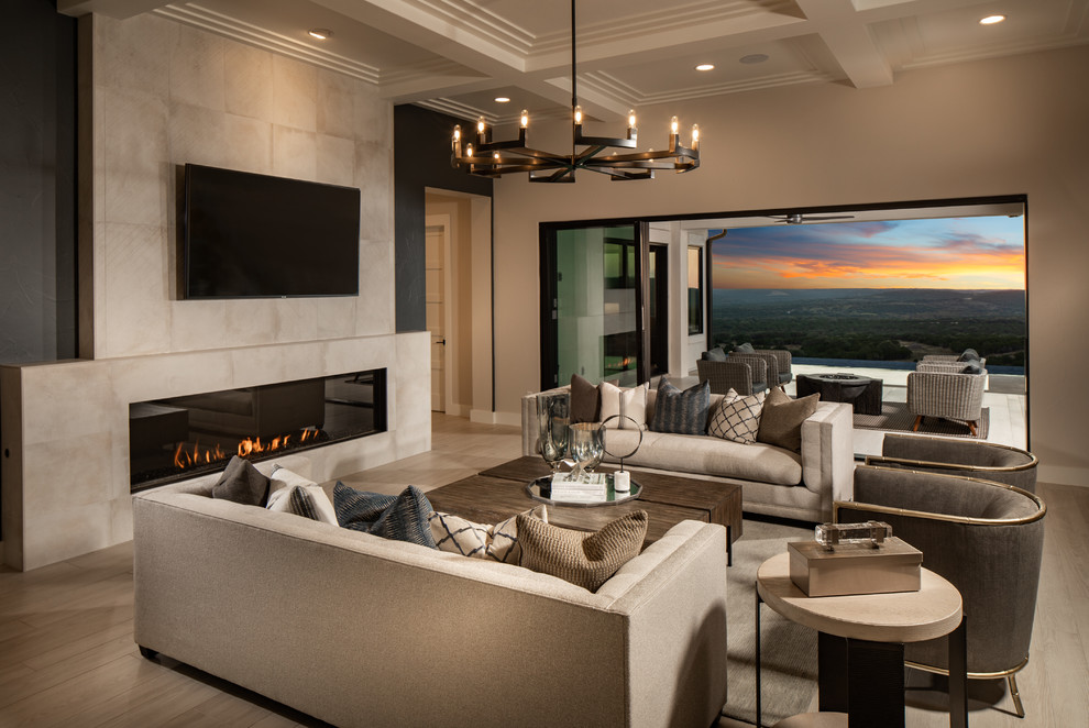 Inspiration for a large contemporary open concept family room in Austin with porcelain floors, a tile fireplace surround, a wall-mounted tv, beige walls, a ribbon fireplace and beige floor.