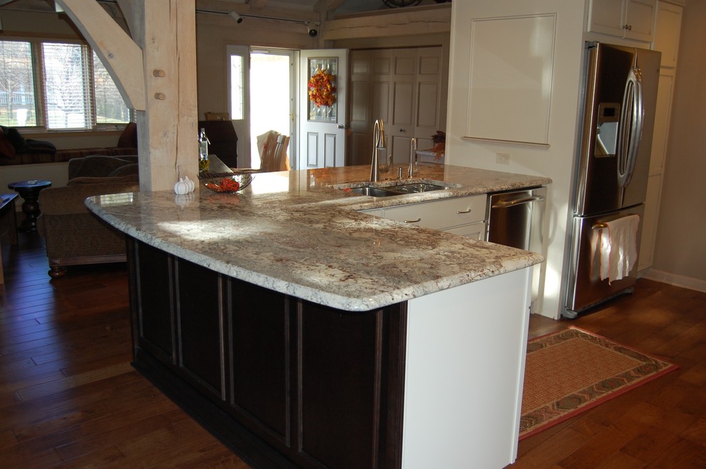 Mid-sized transitional u-shaped medium tone wood floor open concept kitchen photo in Chicago with an undermount sink, flat-panel cabinets, dark wood cabinets, granite countertops, beige backsplash, stone tile backsplash, stainless steel appliances and a peninsula