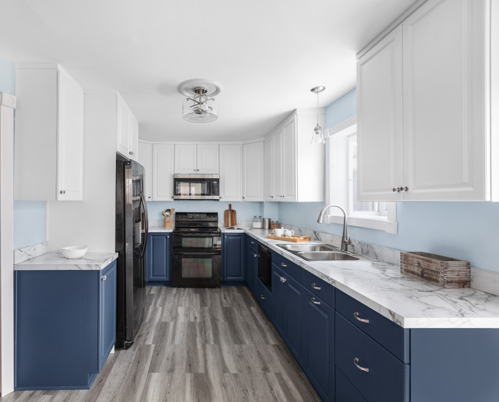 This is an example of a mid-sized traditional galley eat-in kitchen in Philadelphia with a double-bowl sink, raised-panel cabinets, blue cabinets, laminate benchtops, stainless steel appliances, vinyl floors, grey floor and white benchtop.