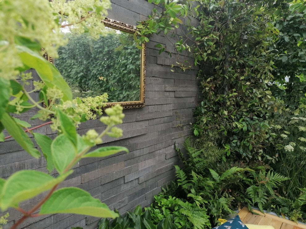 Mittelgroßer Moderner Garten im Sommer, hinter dem Haus mit Sichtschutz und Pflastersteinen in Hampshire