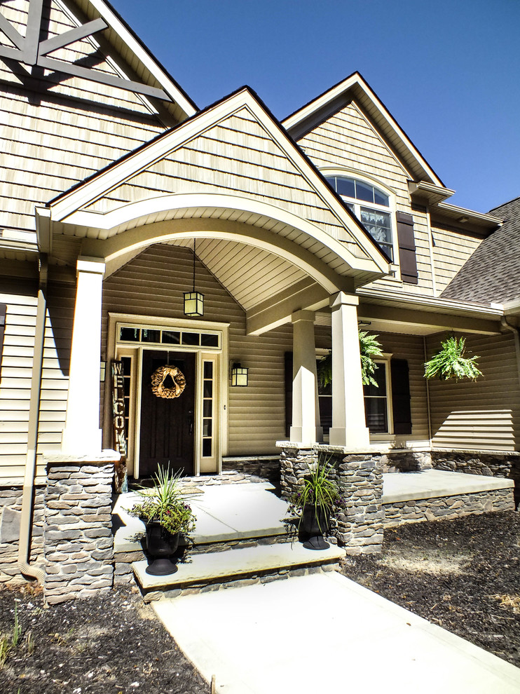 This is an example of a large arts and crafts two-storey beige exterior in Cleveland with vinyl siding.