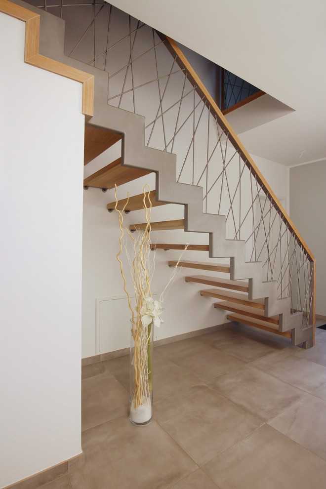 Inspiration pour un escalier droit design de taille moyenne avec des marches en bois et un garde-corps en matériaux mixtes.